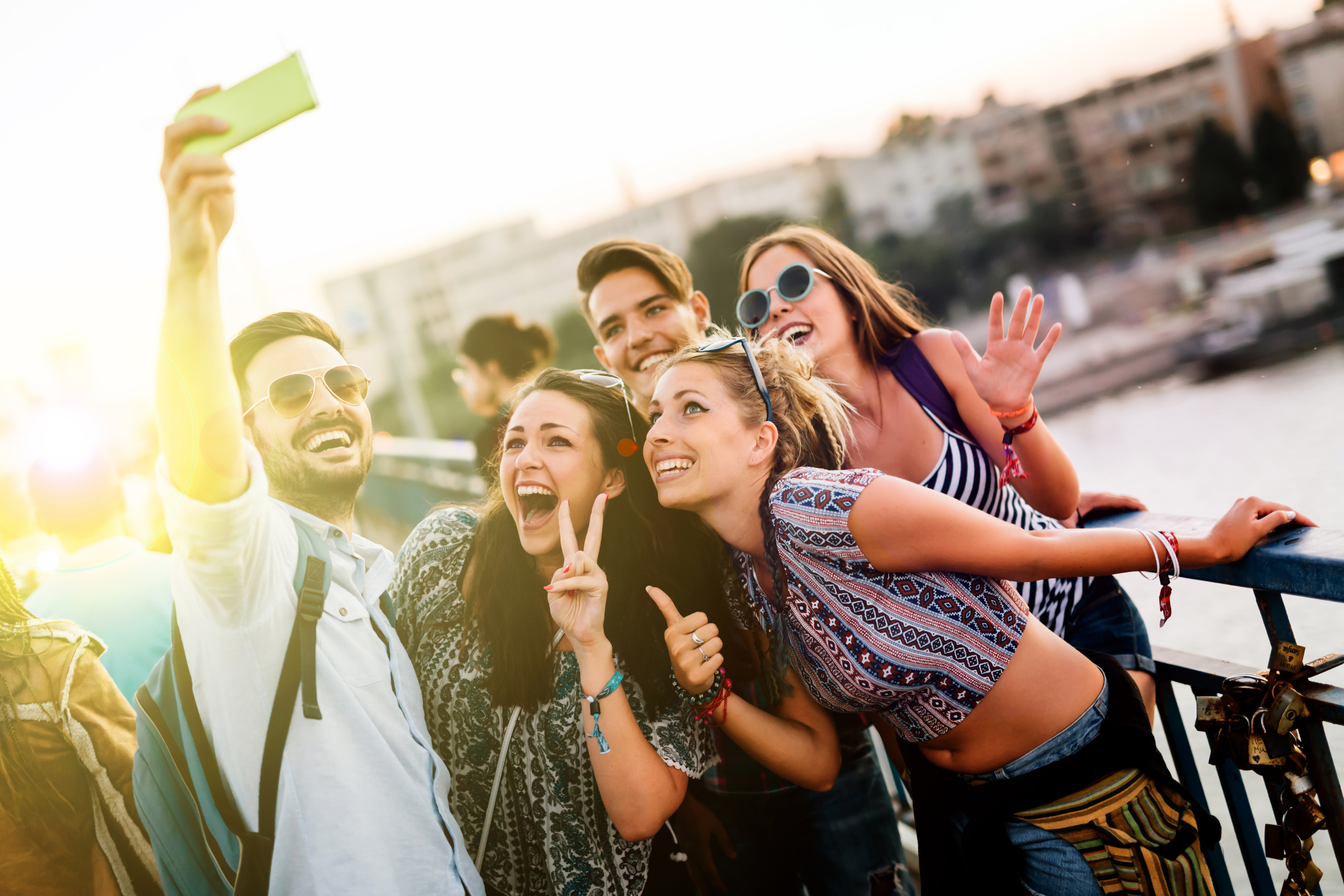 Happy young people taking selfies in city